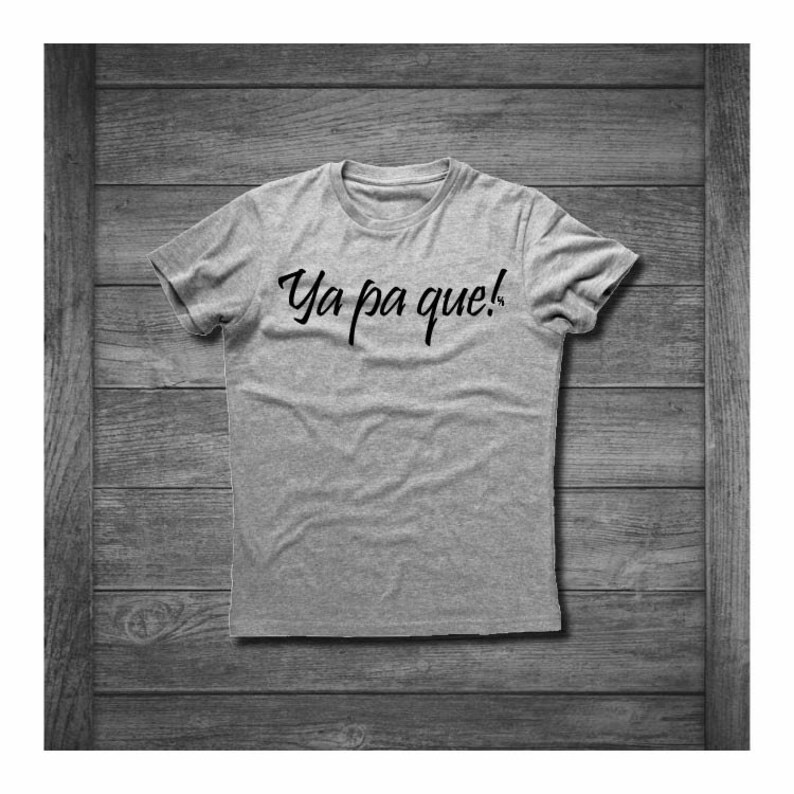 May include: A gray t-shirt with the text "Ya pa que!" printed in black on the front.