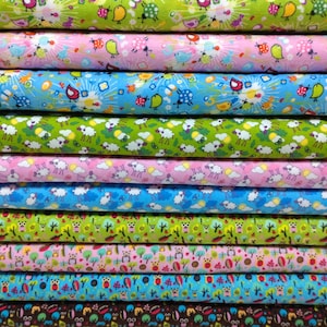 Può includere: Una pila di tessuti colorati con diversi motivi. I motivi includono uccelli, pecore e alberi. Il tessuto è perfetto per il quilting, la cucitura e l'artigianato.