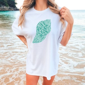 May include: White t-shirt with a green seashell graphic. The seashell is made up of the words "Cape May" in a cursive font.