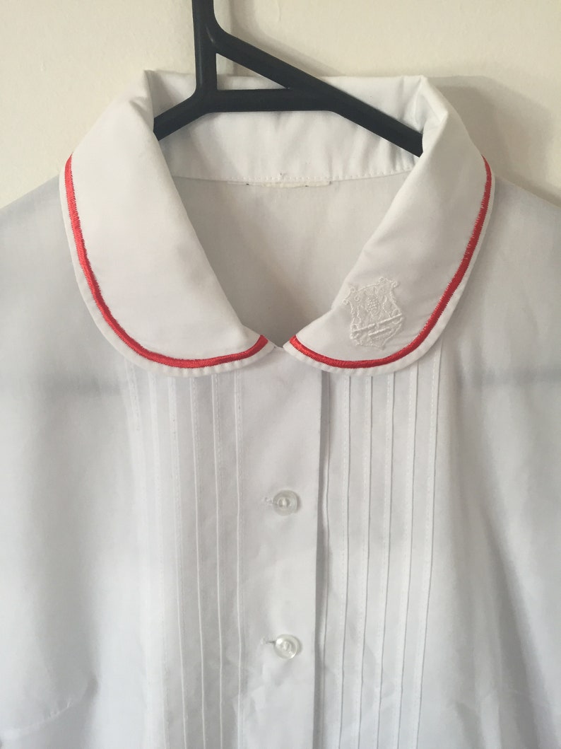 INCREDIBLE 80s White Peter Pan Collar Blouse with Embroidered Royal Crest and Red Piping