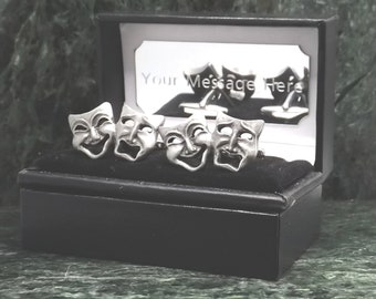 May include: Four silver cufflinks in a black box. Each cufflink features a detailed silver mask with a different expression. The box has a mirrored interior with the text "Your Message Here".