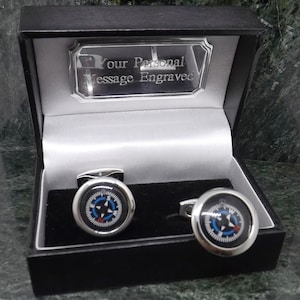 May include: A pair of silver compass cufflinks in a black gift box with a silver plaque that reads "Your Personal Message Engraved".
