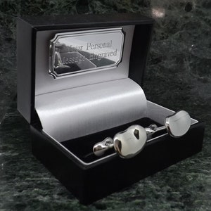 May include: A pair of silver cufflinks in a black box with a silver plaque that reads "Your Personal Message Engraved".