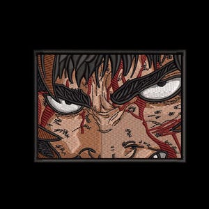 Może przedstawiać: Haftowana naszywka przedstawiająca zbliżenie twarzy postaci z intensywnymi oczami i rozpryskami krwi. Projekt wykorzystuje odcienie brązu, czerni i czerwieni, tworząc dramatyczny efekt. Naszywka jest prostokątna z czarną obwódką.