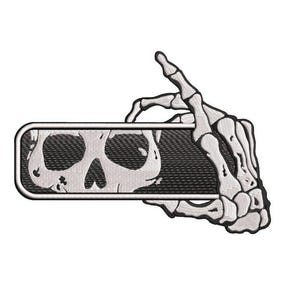 May include: A black and white embroidered patch of a skeleton hand holding a rectangular banner with a skull design.