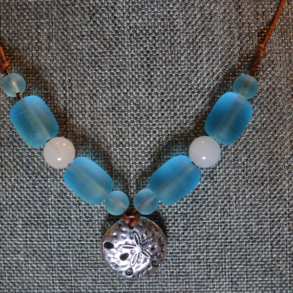 Cultured Sea Glass with a Sand Dollar and Natural White Jade suspended from a 22 inch genuine leather necklace.