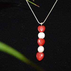Red Hearts accented with Potato Pearls  suspended from a sterling silver chain