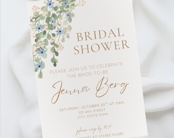 May include: A bridal shower invitation with floral accents. The invitation features the words "BRIDAL SHOWER" in a serif font, with the bride's name, date, time, and location. The invitation is decorated with watercolor flowers.