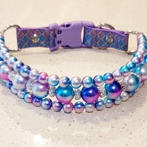 May include: A purple and iridescent dog collar with a mermaid scale pattern and three rows of iridescent pearls.