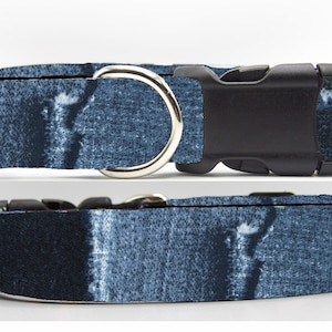 Puede incluir: Un collar para perro de mezclilla azul con una hebilla de plástico negro y un anillo en D plateado.