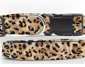 May include: A brown, black, and tan leopard print dog collar with a black plastic buckle and a silver metal D-ring.