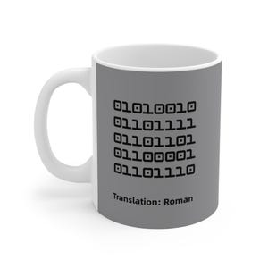 Peut inclure: Tasse en céramique blanche avec une bande grise affichant du code binaire et le texte "Translation: Roman" en noir. La tasse a une anse blanche et une finition brillante.