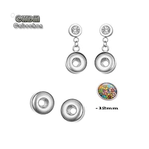 May include: A pair of silver earrings with a clear crystal charm and a silver button charm. The earrings are 12mm in diameter. The image also shows two silver buttons and a 12mm button with a colorful floral design.