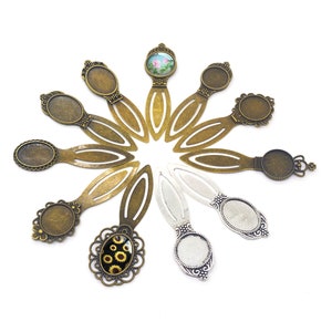 Puede incluir: Surtido de 10 blancos de marcapáginas de metal con cabujones de vidrio ovalados. Los marcapáginas están en una variedad de acabados, incluyendo latón antiguo y plata.