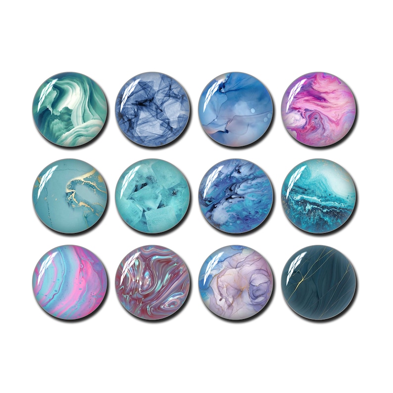 May include: Twelve round, glass-like cabochons with swirling, abstract designs in shades of teal, blue, purple, and pink. Some have gold accents. The cabochons are arranged in three rows of four.