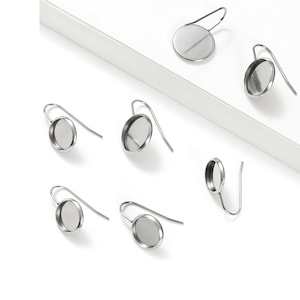 May include: Six silver earring blanks with round bezels. The bezels are designed to hold a cabochon or other embellishment.