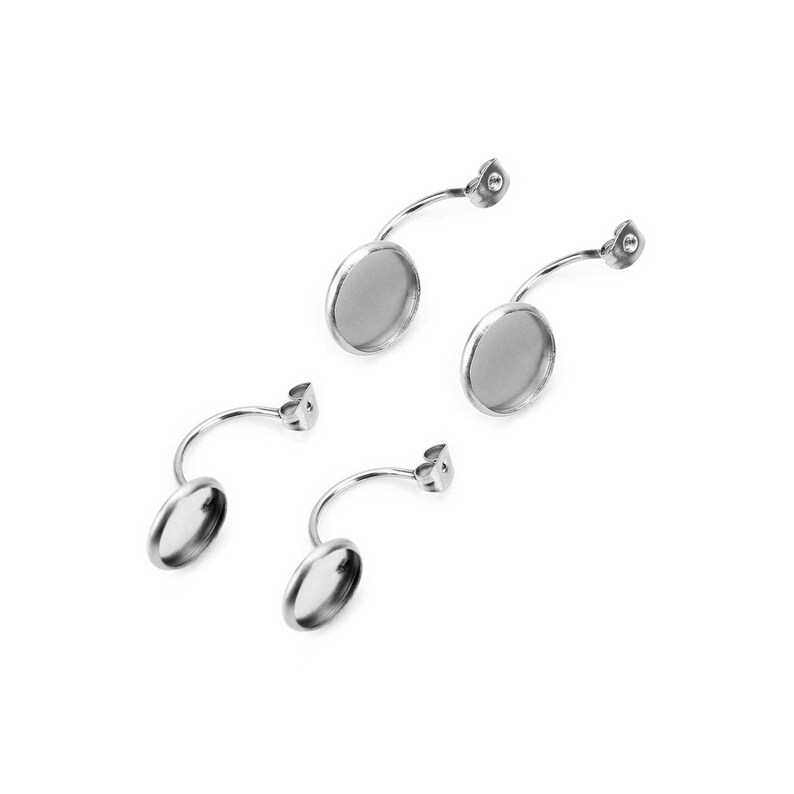 May include: Four silver-toned earring components. Each component features a curved bar with a round, recessed setting for a cabochon or other decorative element. The earring posts are attached to the curved bar.