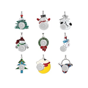 Puede incluir: Nueve dijes de presión con temática navideña que incluyen un muñeco de nieve, un árbol de Navidad, una corona y un gorro de Papá Noel. Los dijes son plateados con detalles de esmalte de colores y tienen un círculo de presión en blanco en el centro.