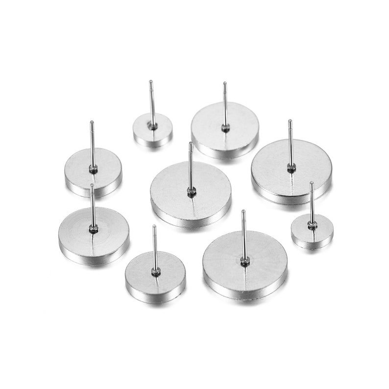 May include: A set of eight silver-toned stud earrings. The earrings are round and have a smooth, polished finish. They are arranged in a scattered pattern on a white background.