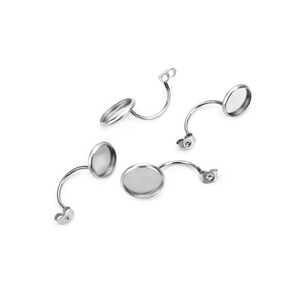 May include: Several silver-toned earring components are arranged against a white background. Each component features a curved post with a flat, circular setting for attaching decorative elements. The components are designed for jewelry making.