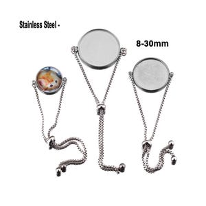 Puede incluir: Tres cadenas de pulsera ajustables de plata con cabujones redondos de vidrio. Los cabujones tienen un diámetro de 8 a 30 mm. Las pulseras son de acero inoxidable.