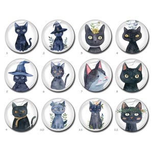 May include: A collection of twelve circular buttons featuring watercolor illustrations of black cats. Each button displays a unique cat portrait, some wearing witch hats, floral crowns, or scarves, numbered one through twelve in a grid layout.