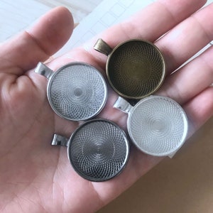 May include: Four silver and bronze pendant trays with a decorative pattern. The trays are round and have a raised edge.