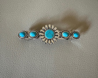 May include: Silver hair clip with a turquoise flower design and five turquoise stones.