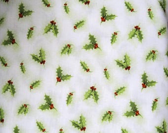 May include: White fabric with a repeating pattern of green holly leaves and red berries. The leaves have a watercolor effect, and the berries are small and round. The design is scattered across the fabric.