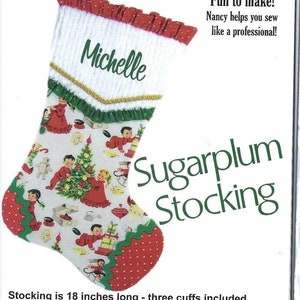 May include: A Christmas stocking sewing pattern with a red and white stocking with a green and white trim. The stocking is decorated with a Christmas tree and children. The pattern includes instructions and pattern pieces for three stockings. The text on the pattern reads "Sugarplum Stocking" and "Stocking is 18 inches long - three cuffs included".