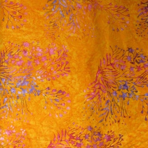 May include: Orange fabric with a floral pattern in shades of pink and purple. The fabric has a batik style design.
