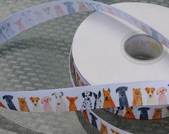 May include: White ribbon with a repeating pattern of watercolour-style dog breeds. The ribbon is wrapped around a white spool. The dogs are in shades of brown, black, and grey.