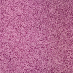 May include: Close-up of a fabric with a speckled pattern in shades of purple and pink. The fabric has a textured appearance, with darker purple spots scattered across a lighter pink background. The overall effect is a mottled, visually interesting design.