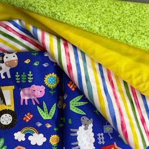 May include: A collection of colorful fabrics, including a blue fabric with farm animal illustrations, a striped fabric with red, yellow, and blue stripes, and solid yellow and green fabrics. The fabrics are layered and folded.