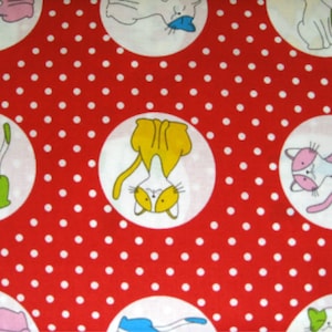 May include: Red fabric with white polka dots and circular illustrations of cartoon cats. The cats are in various poses and colors, including white, pink, yellow, and blue, with green accents.