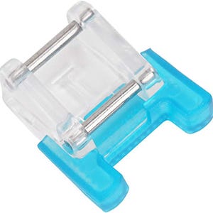 May include: A clear plastic sewing machine foot with a blue plastic base and a metal spring. The foot is designed to be used for sewing on a sewing machine.