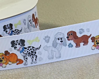 May include: A white grosgrain ribbon featuring a repeating pattern of cartoon dogs, including spotted Dalmatians, brown dachshunds, and white poodles, interspersed with small light green bone shapes and grey paw prints on a textured fabric surface.