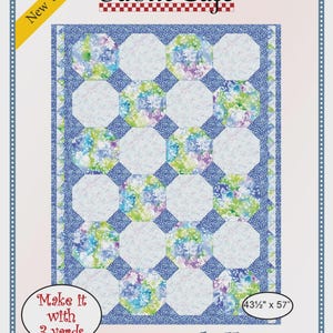 May include: A Fabric Café quilt pattern titled Snowball, featuring a blue, green, and white floral design with octagonal blocks. The pattern includes the text New Version, 090931-01, Make it with 3 yards, and the finished size of 43.5 inches by 57 inches.