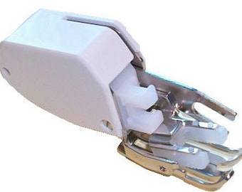 May include: White and silver sewing machine foot attachment with a white plastic cover.