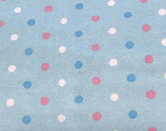 May include: A light blue fabric featuring a repeating pattern of small, evenly spaced polka dots in alternating colors of white, pink, and dark blue. The dots are arranged in a grid-like formation across the entire surface of the material.