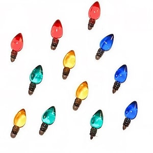 Pode incluir: Uma coleção de lâmpadas de Natal coloridas em vermelho, azul, verde e amarelo. Cada lâmpada tem formato de gota e uma base marrom escura. As lâmpadas estão espalhadas sobre um fundo branco, sugerindo um tema festivo.
