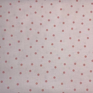 Può includere: Un tessuto bianco con un motivo ripetitivo di piccoli pois rosa.