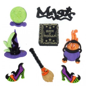 May include: A collection of Halloween-themed embellishments, including a green orb, a witch's hat, a book with the text "Book of Spells", a cauldron, a broom, a pair of high-heeled shoes, and the word "Magic". The items are in various colors.