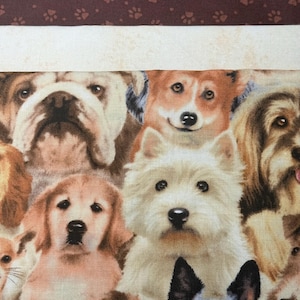Puede incluir: Un panel de tela con un estampado de diferentes razas de perros. Incluye un bulldog, un corgi, un golden retriever y un terrier. El borde superior tiene un diseño de huellas de patas de color marrón oscuro. Los perros son de varios colores, como marrón, blanco y negro.