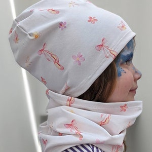 May include: White beanie and neck warmer set with a pink floral and ballet shoe print.