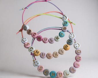 Pulsera escolar ajustable con cuentas sonrientes, ideal para el regreso a clases. Incluye un cono escolar.