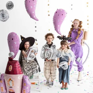 Puede incluir: Cuatro ni&ntilde;os disfrazados para Halloween sostienen varios globos. Los ni&ntilde;os llevan un disfraz de bruja, una chaqueta plateada, un vestido azul y un mono morado. Los globos tienen forma de fantasmas, n&uacute;meros y una casa. El fondo es blanco con confeti en el suelo.