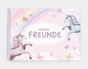 Può includere: Un libro rosa e viola con un arcobaleno e due unicorni. Il libro ha il testo "Meine FREUNDE" sulla copertina.