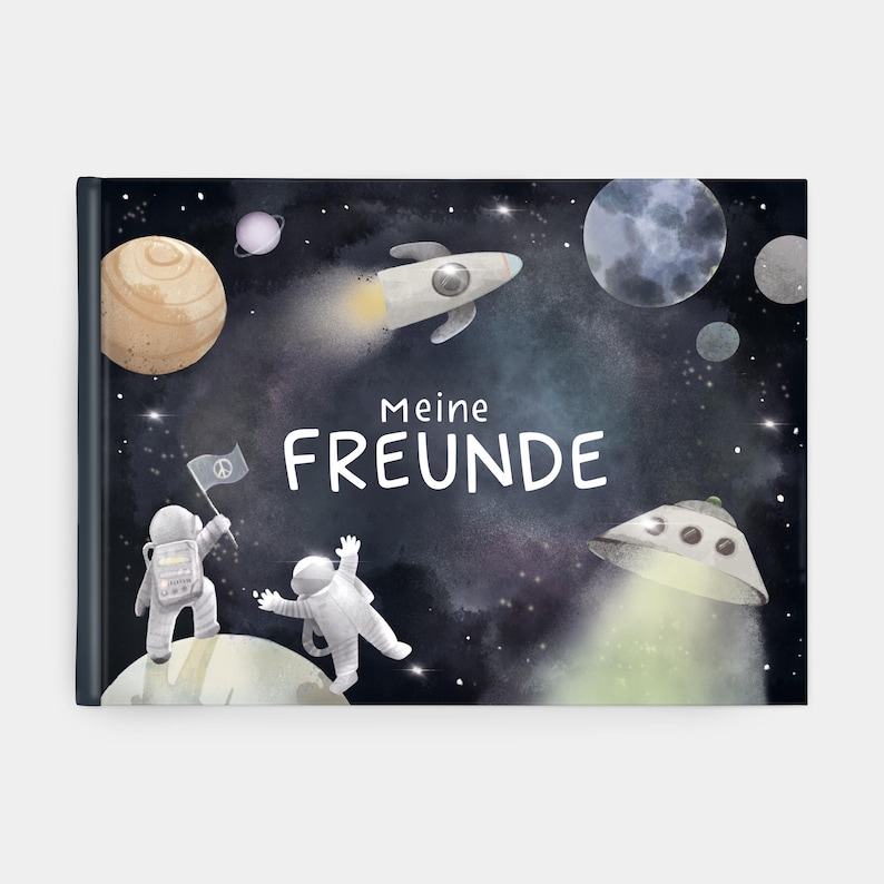 Op de afbeelding: Een hardcover boek met een ruimte-thema illustratie. De omslag toont een donkerblauwe achtergrond met planeten, een raket en twee astronauten. De Duitse tekst "Meine FREUNDE" is prominent aanwezig.