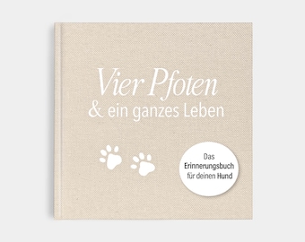 May include: A beige-colored book with the text "Vier Pfoten & ein ganzes Leben" and paw prints. A white circle contains the text "Das Erinnerungsbuch für deinen Hund". The book is a pet-themed item.